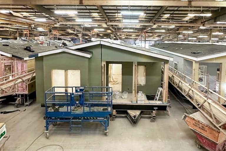 Energy-efficient single-story prefab home staged inside a clean, modern U.S. housing factory
